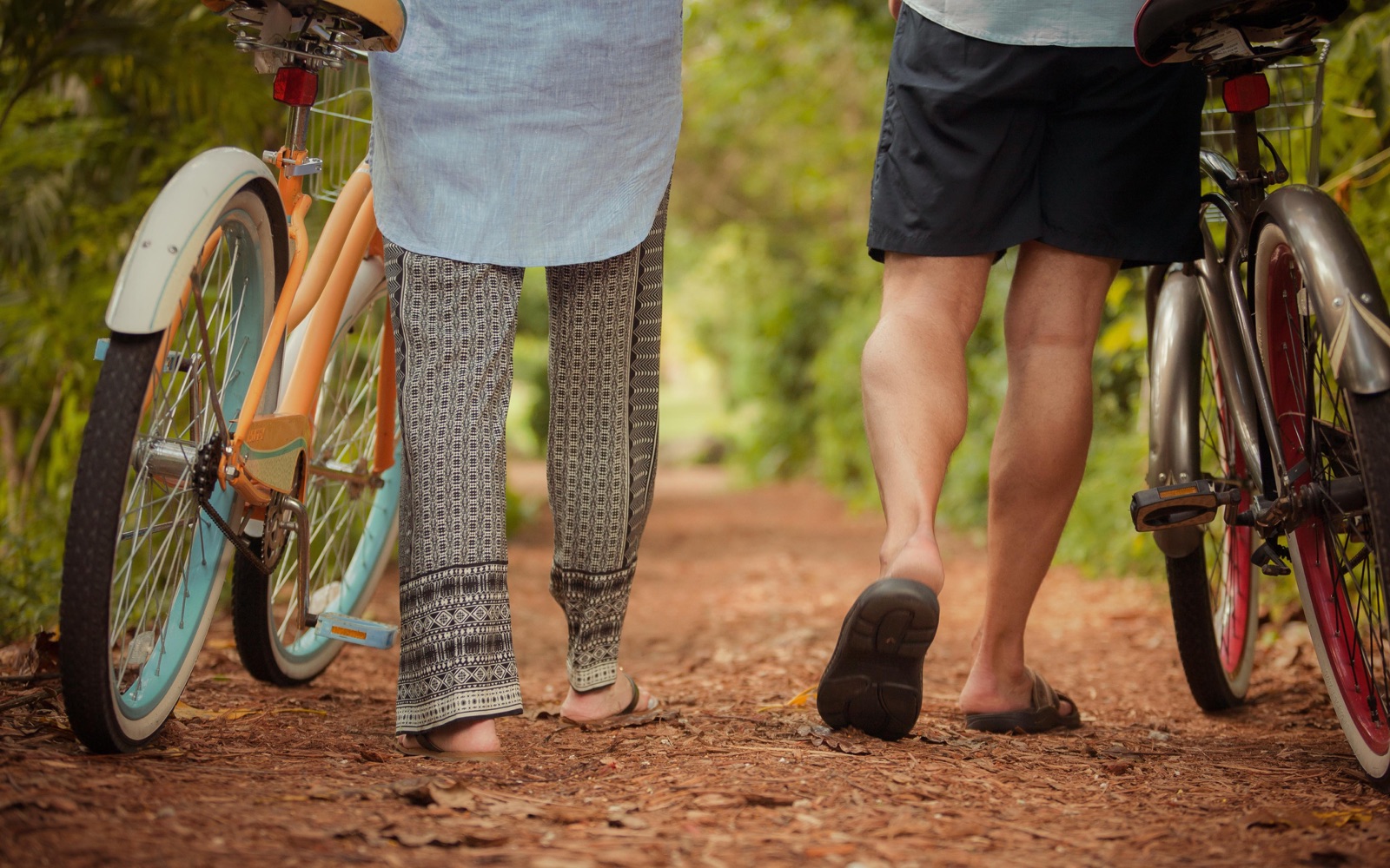 Two guests walking bicycles along a path on the Hippocrates campus